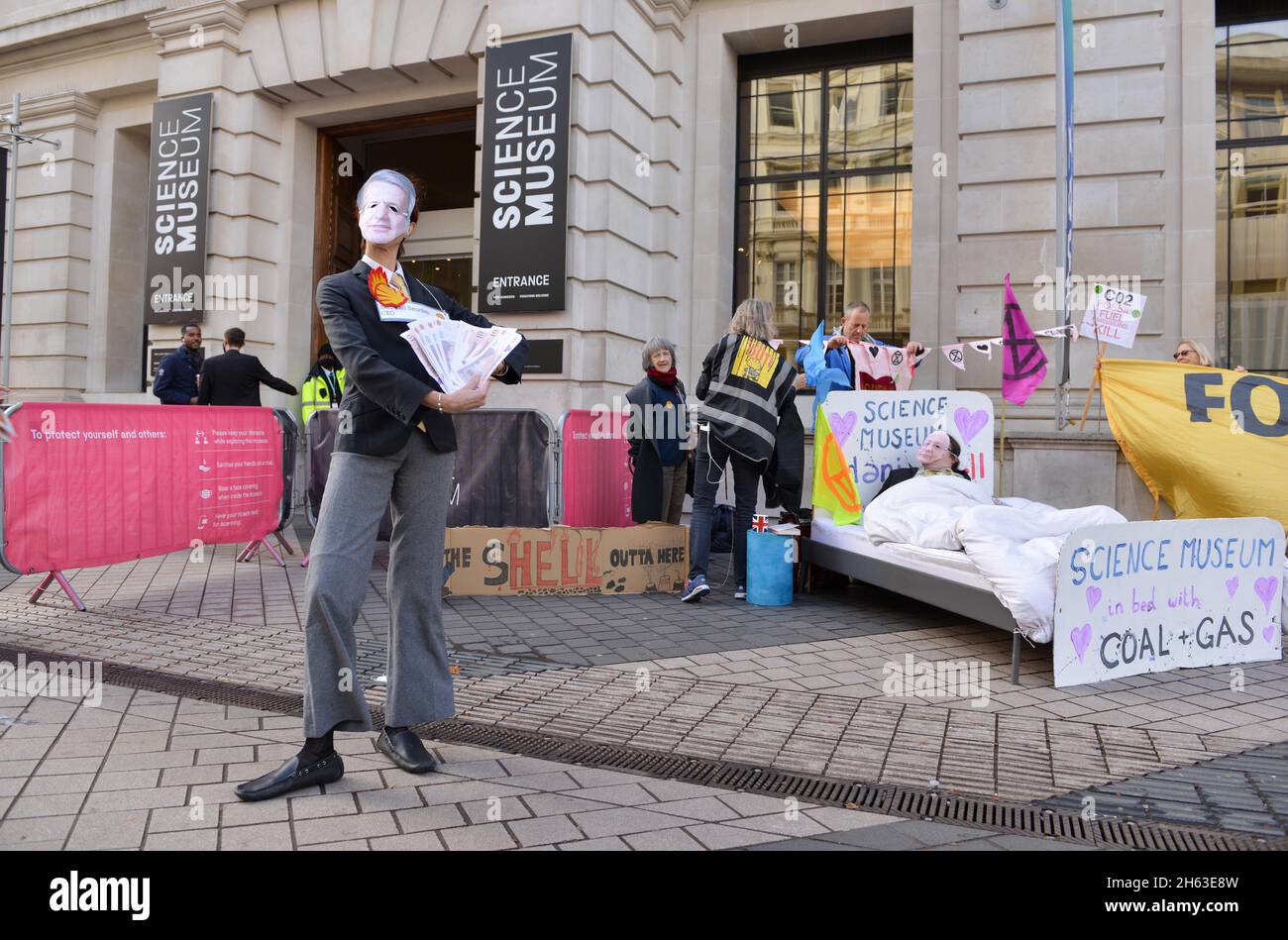 London, Großbritannien. November 2021. Ein Protestler, der als Shell-CEO Ben van Beurden gekleidet ist, posiert während der Demonstration mit gefälschtem Geld.Aktivisten des Extinction Rebellion veranstalteten einen Protest gegenüber dem Science Museum in South Kensington gegen das Sponsoring des Museums durch die fossilen Energiekonzerne Shell und Adani. Kredit: SOPA Images Limited/Alamy Live Nachrichten Stockfoto