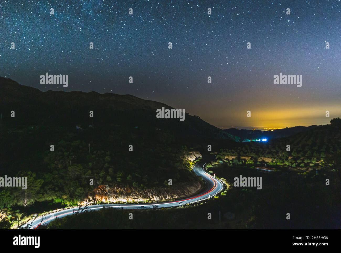 Leichte Spur von Autos auf einer kurvenreichen Straße mit den Sternen oben (milkey way) in andalusien, spanien Stockfoto