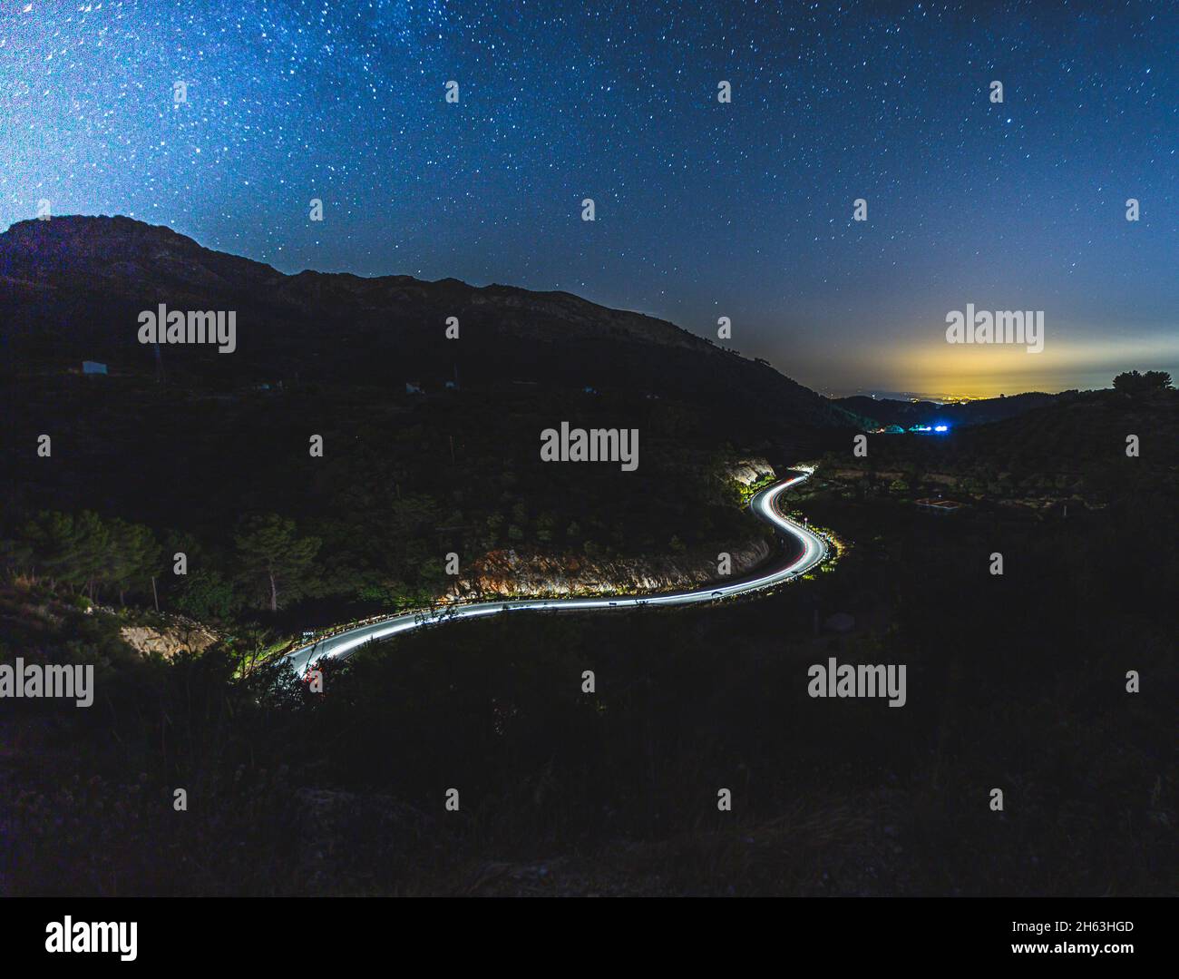 Leichte Spur von Autos auf einer kurvenreichen Straße mit den Sternen oben (milkey way) in andalusien, spanien (hdr) Stockfoto