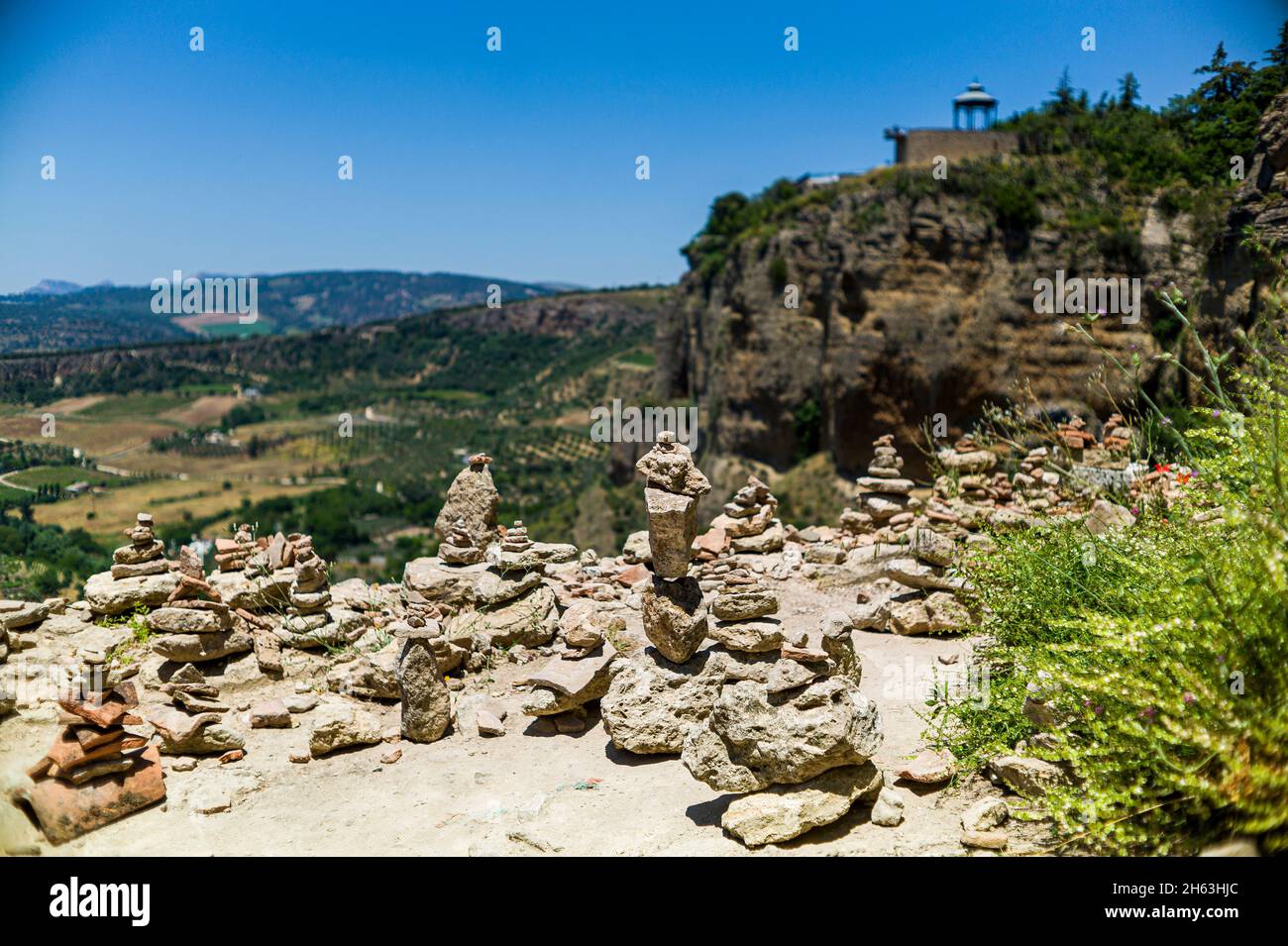 Pyramiden aus Steinen und Keramikstücken als Symbol für Harmonie, Gleichgewicht, Seelenfrieden unter den Mauern der Stadt ronda, andalusien, Spanien vor dem Hintergrund der Berge. Stockfoto