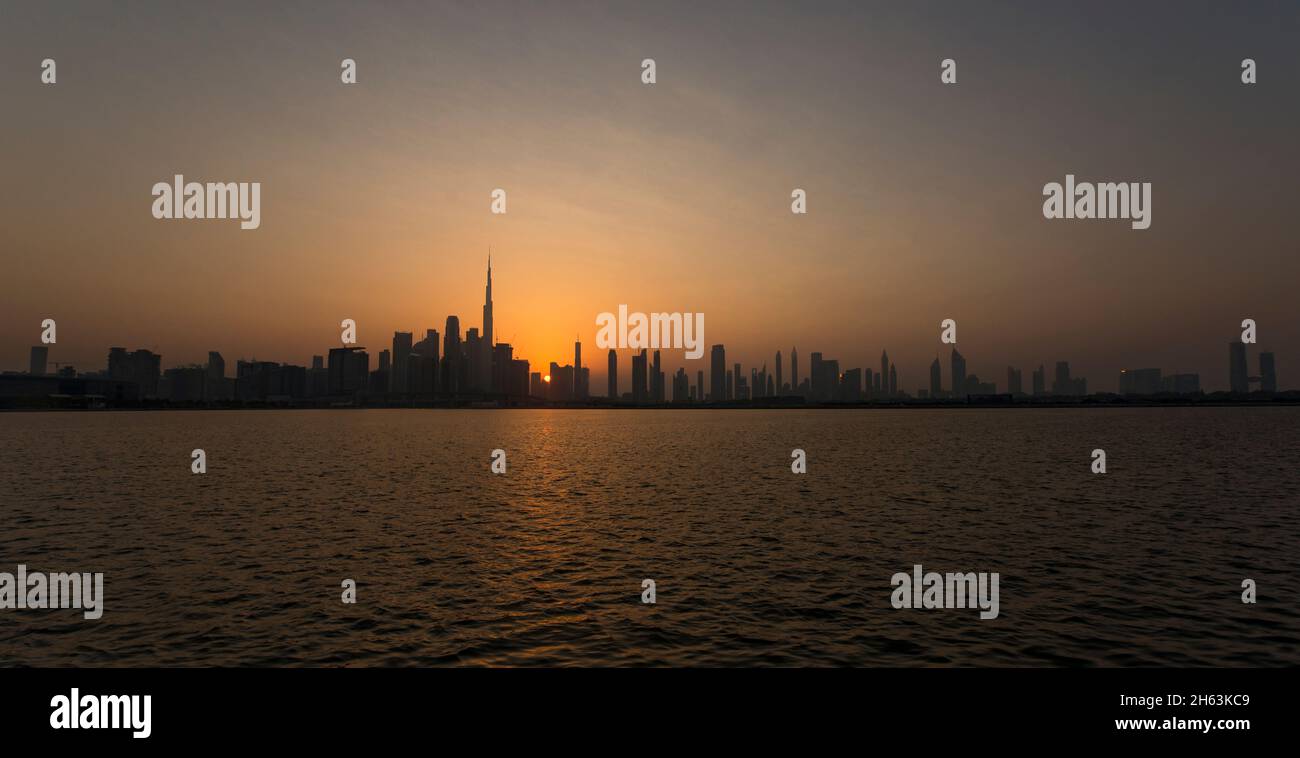 Panoramablick auf den Burj Khalifa und die Hochhäuser bei Sonnenuntergang über dem Dubai Canal VAE Stockfoto