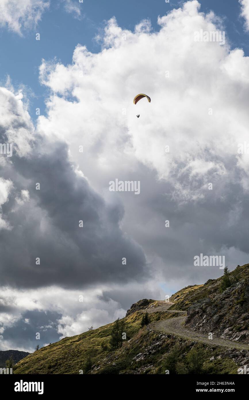 Ein Gleitschirm im Flug über den thurntaler rundweg vor Sturmwolken, Talstadt sillian, villgratener Berge, osttirol, bezirk lienz, tirol, österreich Stockfoto