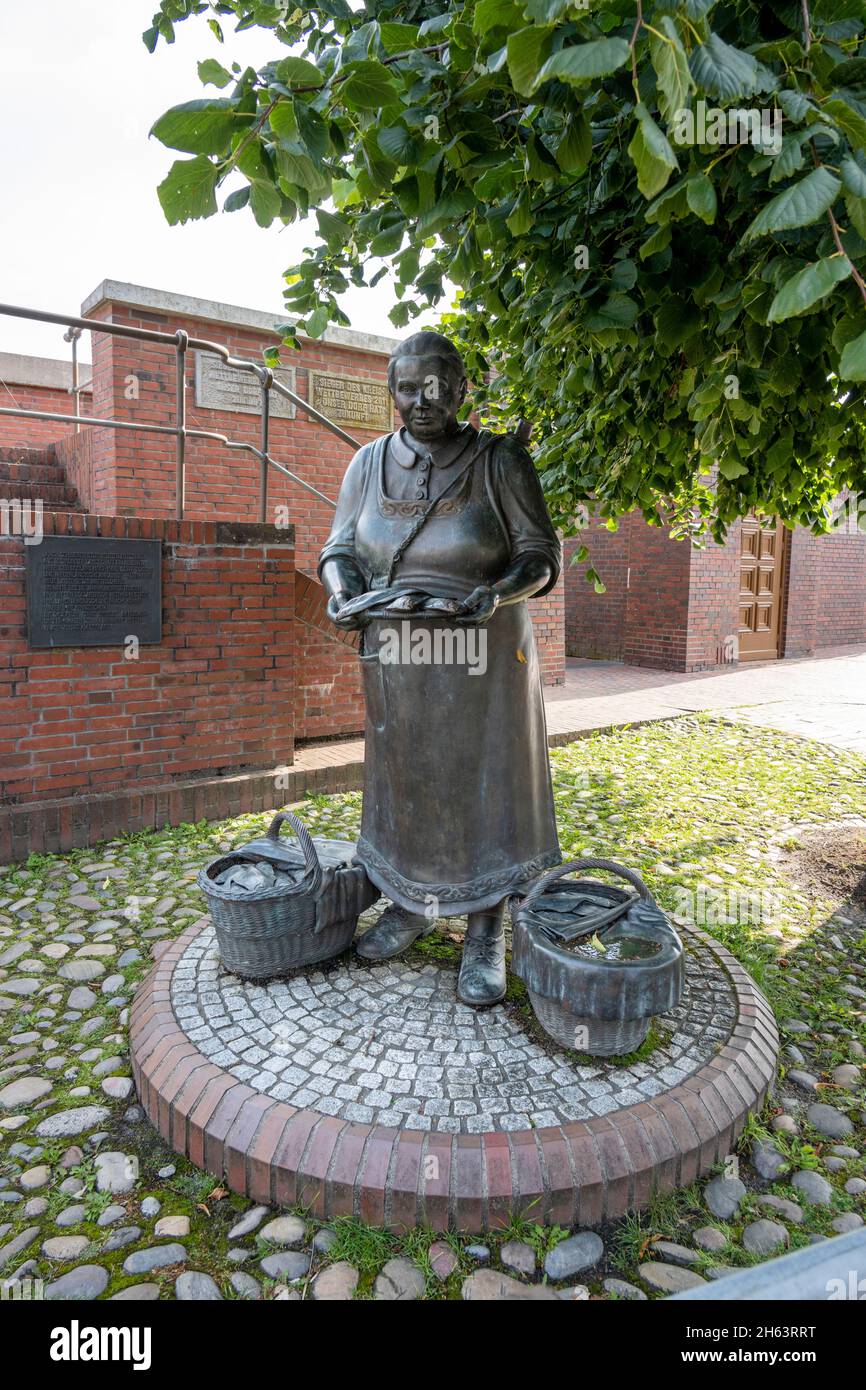deutschland, niedersachsen, ostfriesland, ditzum, Bronzeskulptur, die Fischerfrau Tante dientje am sielwerk. Stockfoto
