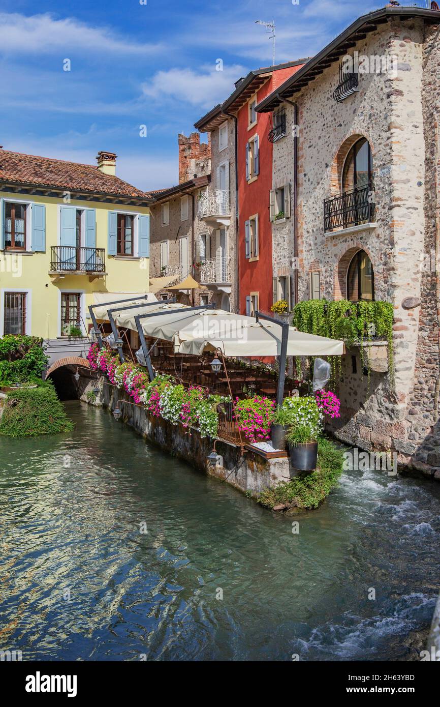 Restaurant Terrasse mit Blumen auf dem fluss mincio, borghetto, Bezirk valeggio sul mincio, Mühlendorf, Po-Tal, provinz verona, venetien, italien Stockfoto