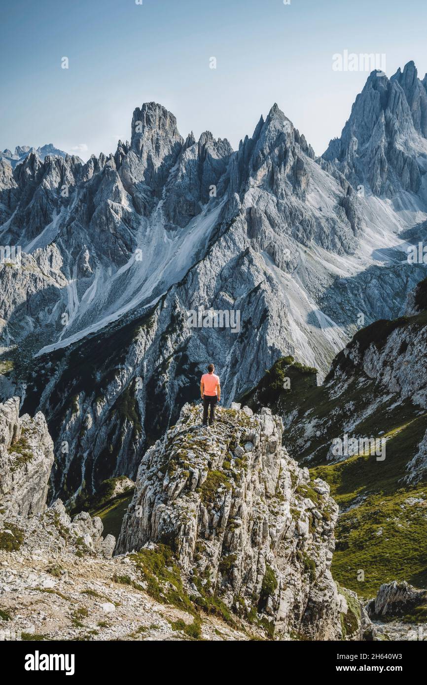 Der Wanderer steht und bewundert die atemberaubende Schönheit der beeindruckenden zerklüfteten Gipfel der cadini di misurina-Berggruppe in den dolomiten, italien, Teil des Nationalparks Tre cime di Levaredo. Stockfoto