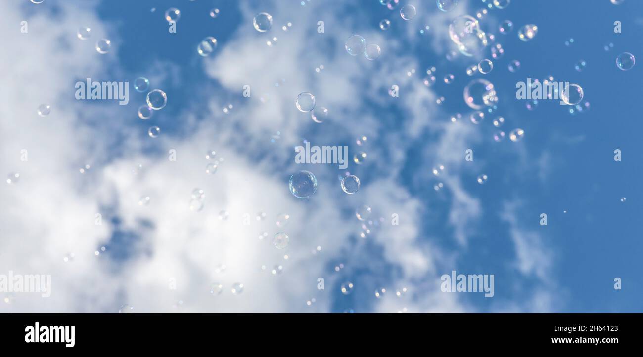 Seifenblasen vor einem weiß-blauen Himmel Stockfoto