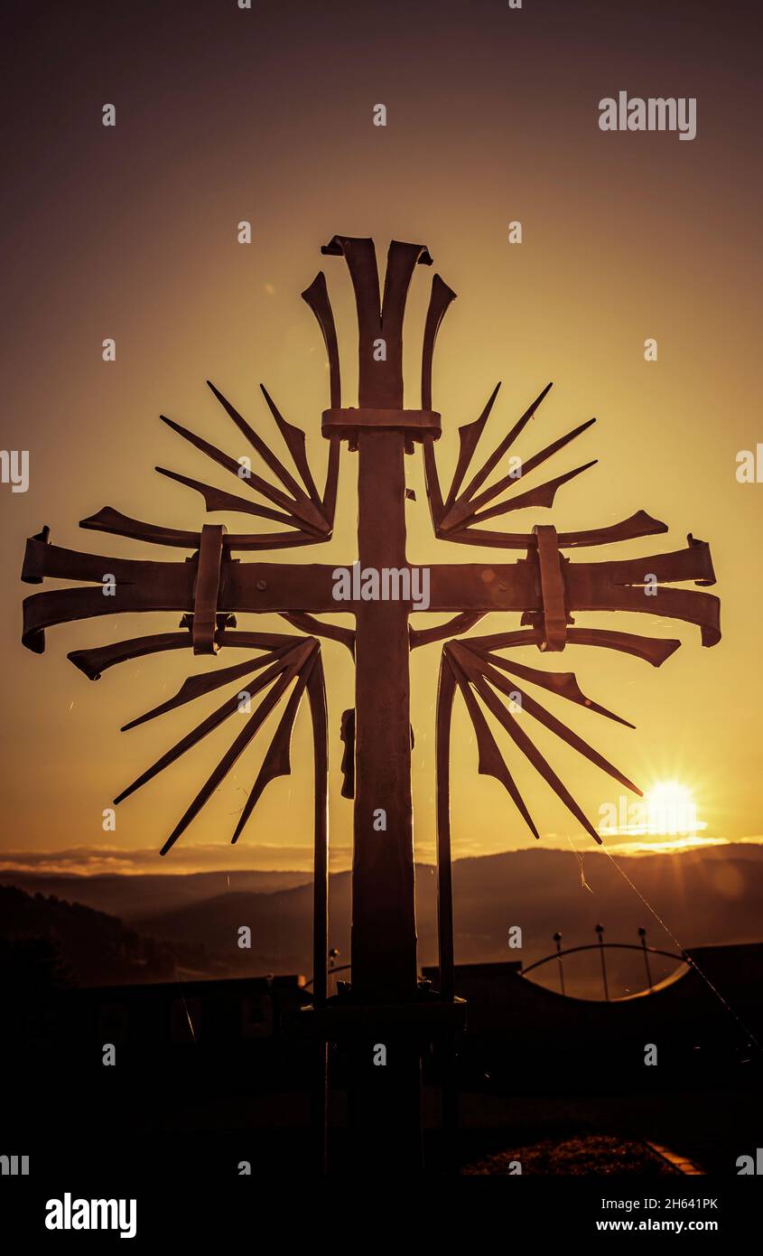 sonnenaufgang hinter einem schmiedeeisernen Kreuz Stockfoto
