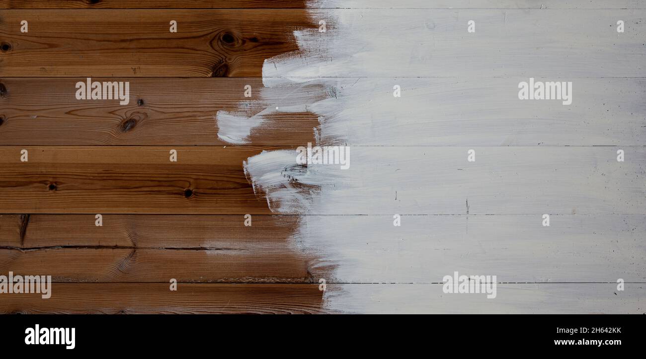 Halb fertig bemalte Holzwand mit weißer Farbe Stockfoto