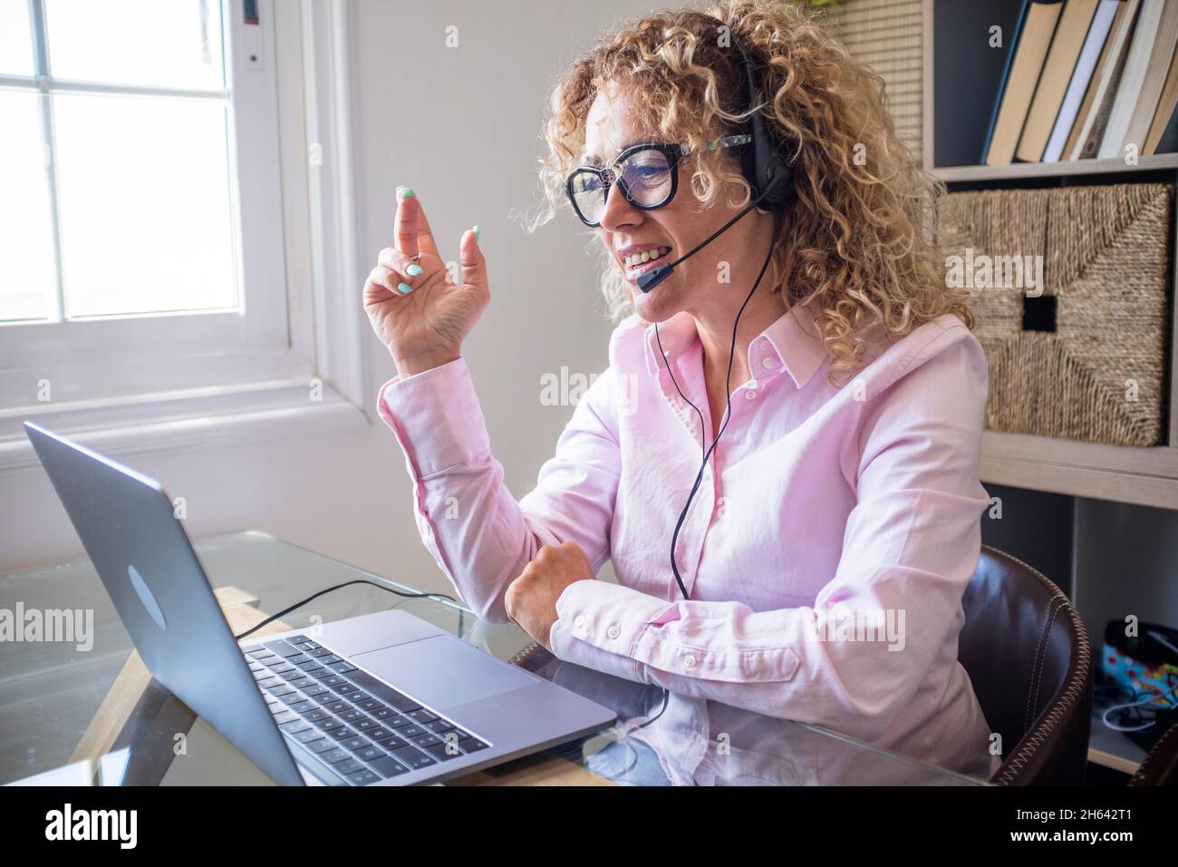 Erwachsene Unternehmer hübsche Frau sprechen auf Videokonferenz Konferenz Zoom mit Laptop-Computer und Kopfhörer mit Mikrofon - Konzept der Geschäftsfrau und Frelance Lebensstil Stockfoto