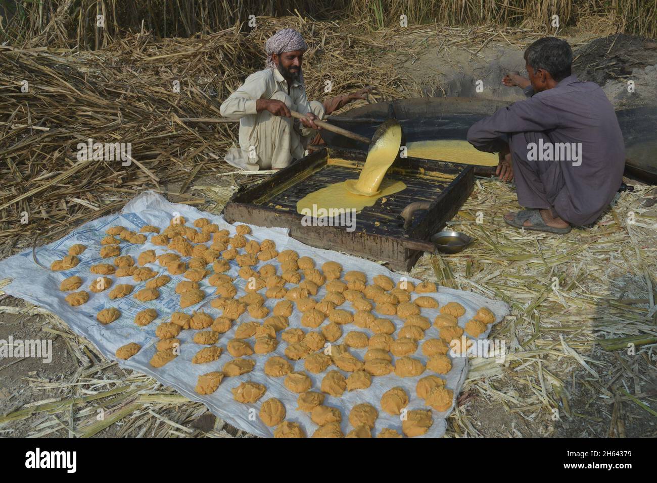 Lahore, Pakistan. November 2021. Pakistanische Bauern sind damit beschäftigt, die traditionelle Dschaggery (Gur) auf dem Zuckerrohrfeld im Slumgebiet der Provinzhauptstadt Lahore zu bauen. (Foto von Rana Sajid Hussain/Pacific Press) Quelle: Pacific Press Media Production Corp./Alamy Live News Stockfoto