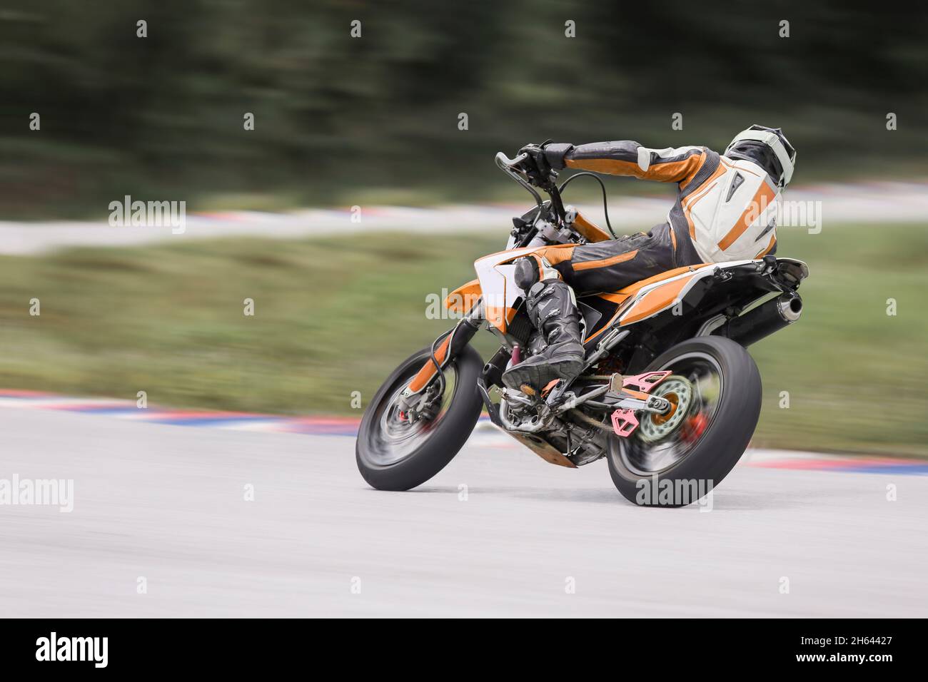 Motorrad-Praxis lehnt sich in eine schnelle Ecke auf der Strecke Stockfoto
