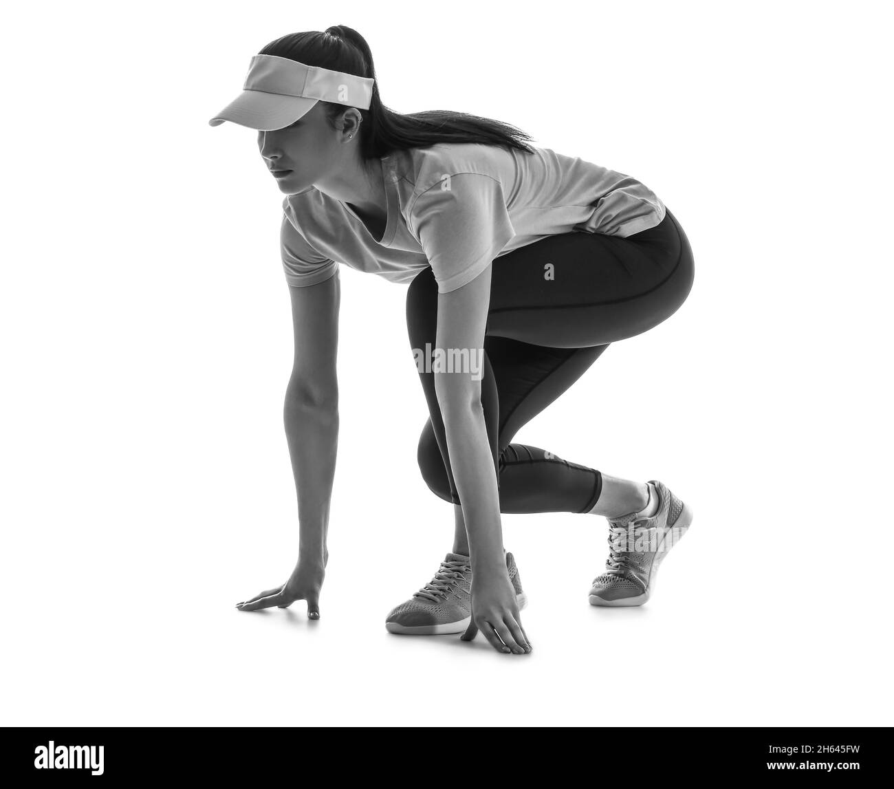 Silhouette der sportlichen jungen Frau in Kräuse-Startposition auf weißem Hintergrund Stockfoto