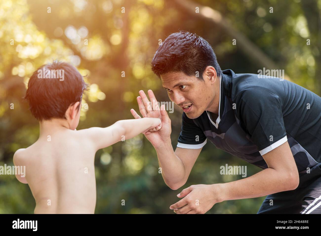 Kid Boxing. Junge Boxer üben muay Thai Schläge mit Vater Trainer. Stockfoto