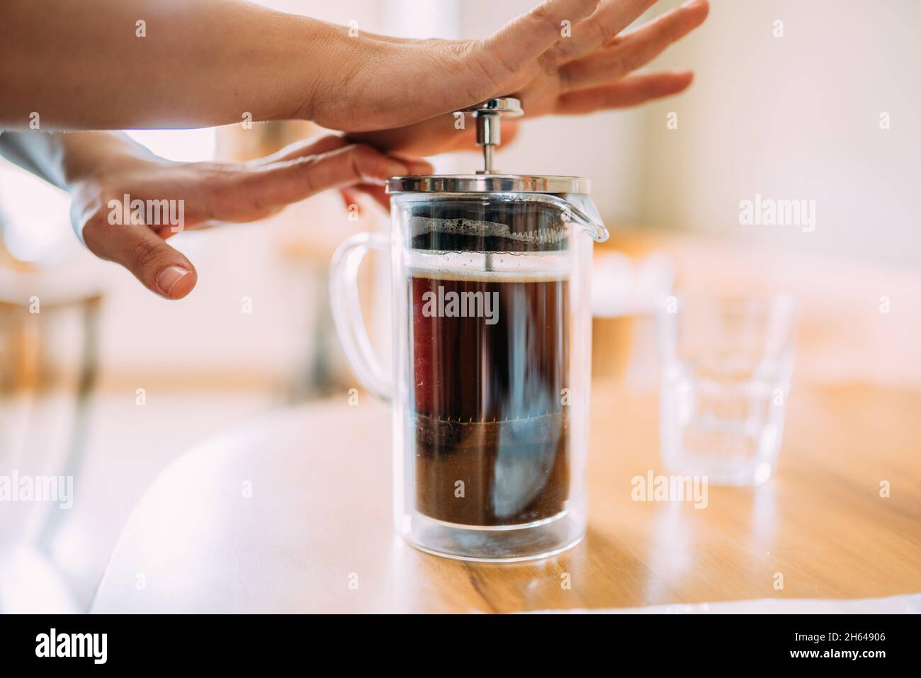 Französischer Presskaffee. Freunde warten auf Kaffee am Tisch in einem brasilianischen Café-Shop. Stockfoto