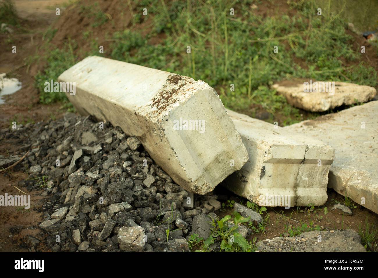 Auf dem Boden liegende Fragmente von Betonkonstruktionen. Die Struktur des groben Materials ist grau. Bau in Russland. Außenaufnahmen Stockfoto