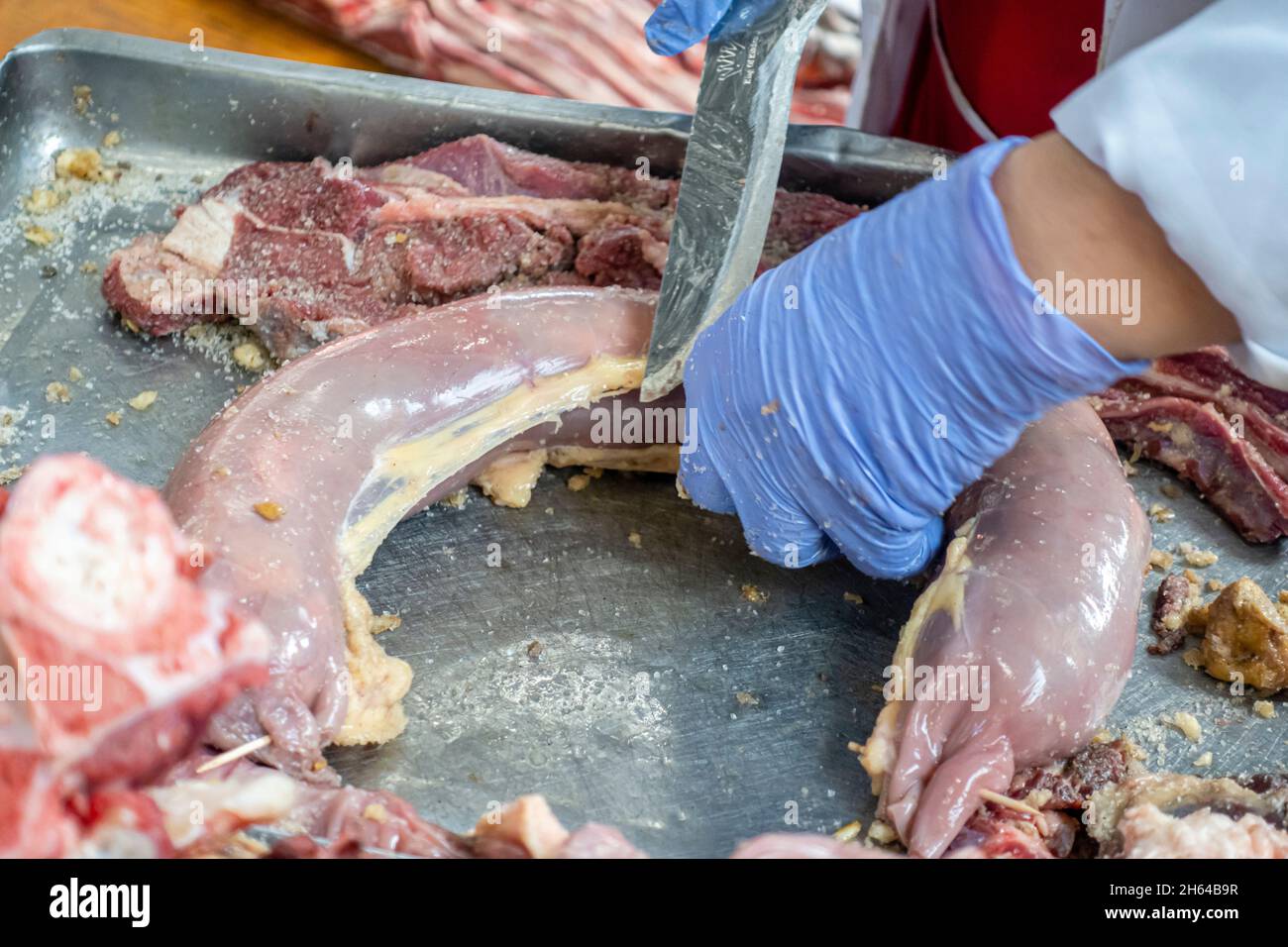 Qazy, Pferdefleischwurst wird in qarta (Pferdedarm) gestellt. Von Hand in Handschuhen verpackt, um auf dem Fleischmarkt Altyn Orda, Almaty, Kasachstan, verkauft zu werden Stockfoto