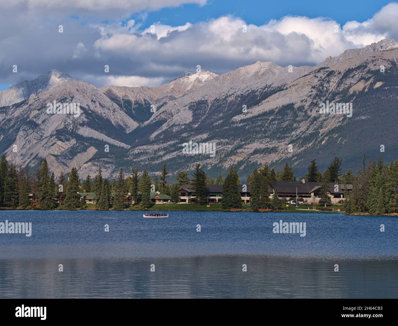 Schöner Blick auf den Beauvert Lake in Jasper, Alberta, Kanada, in den Rocky Mountains mit Kanufahrern, Urlaubsort umgeben von Bäumen. Stockfoto