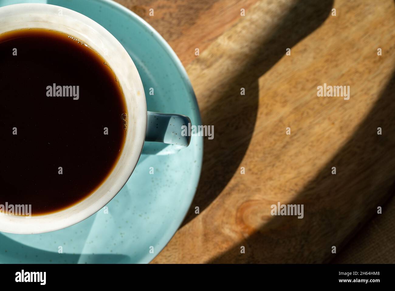 Tasse Kaffee auf Holzschreibtisch Hintergrund, flach liegend, Nahaufnahme. Stockfoto