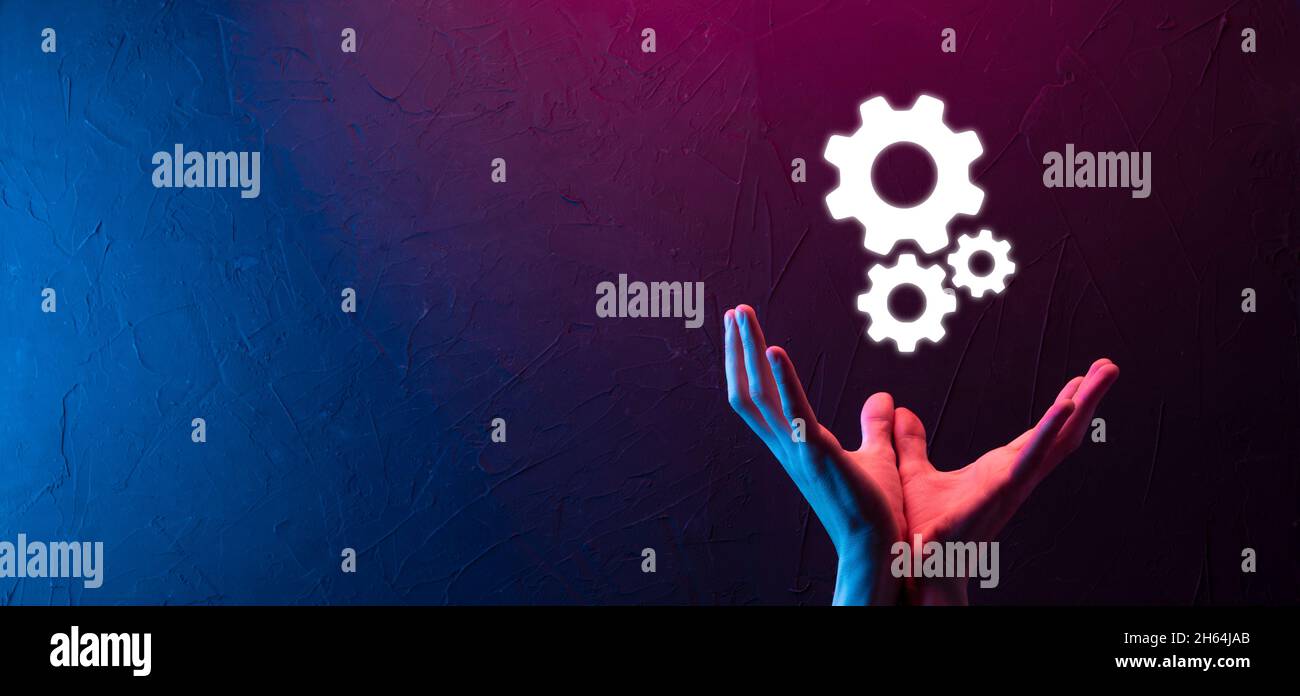 Geschäftsmann im Anzug hält Metallgetriebe und Zahnräder Mechanismus der Interaktion Teamarbeit Konzept, Hand halten Gruppe von virtuellen Zahnräder Rad. Stockfoto