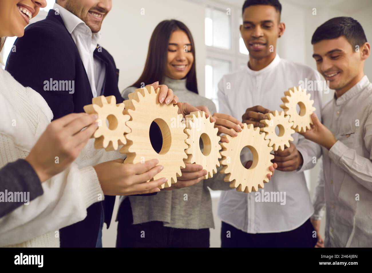 Menschen verbinden Getriebe als Metapher für gut koordinierte Arbeit und Aufbau eines effektiven Geschäftssystems Stockfoto