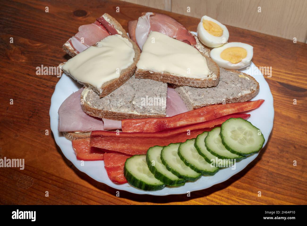 Ein Teller mit Sandwiches und Gurken, Paprika und Eiern auf der Seite Stockfoto