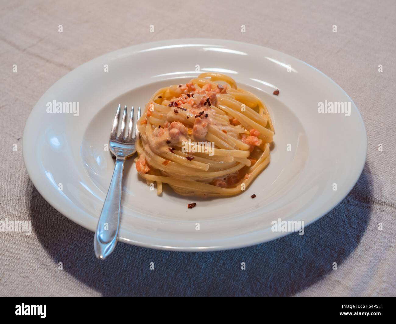 Lachs Linguini oder Pasta al Salmone con Panna mit Peperoncini Chili und Sahnesauce Stockfoto