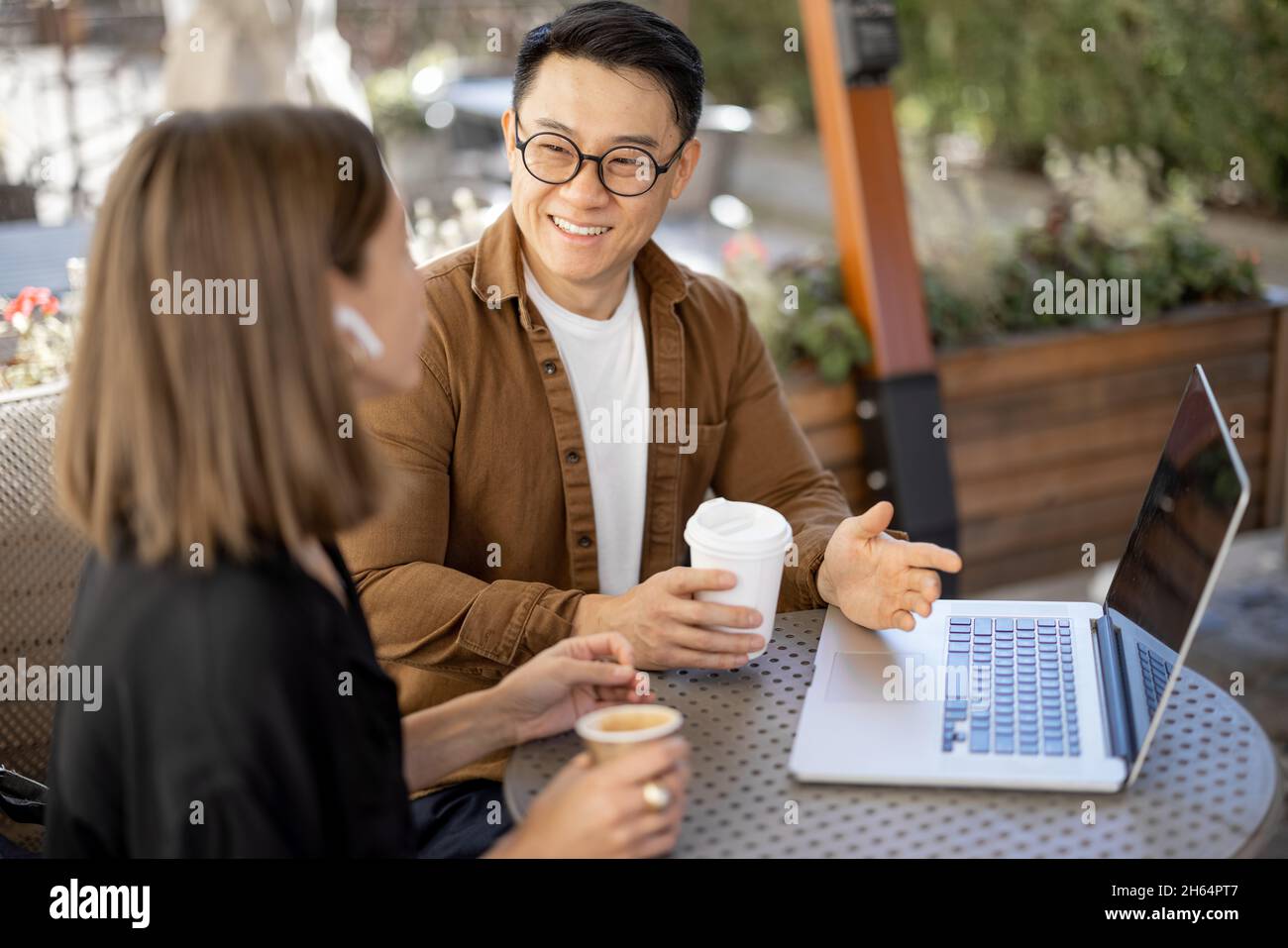 Menschen, die im Café mit einem Laptop reden und arbeiten Stockfoto