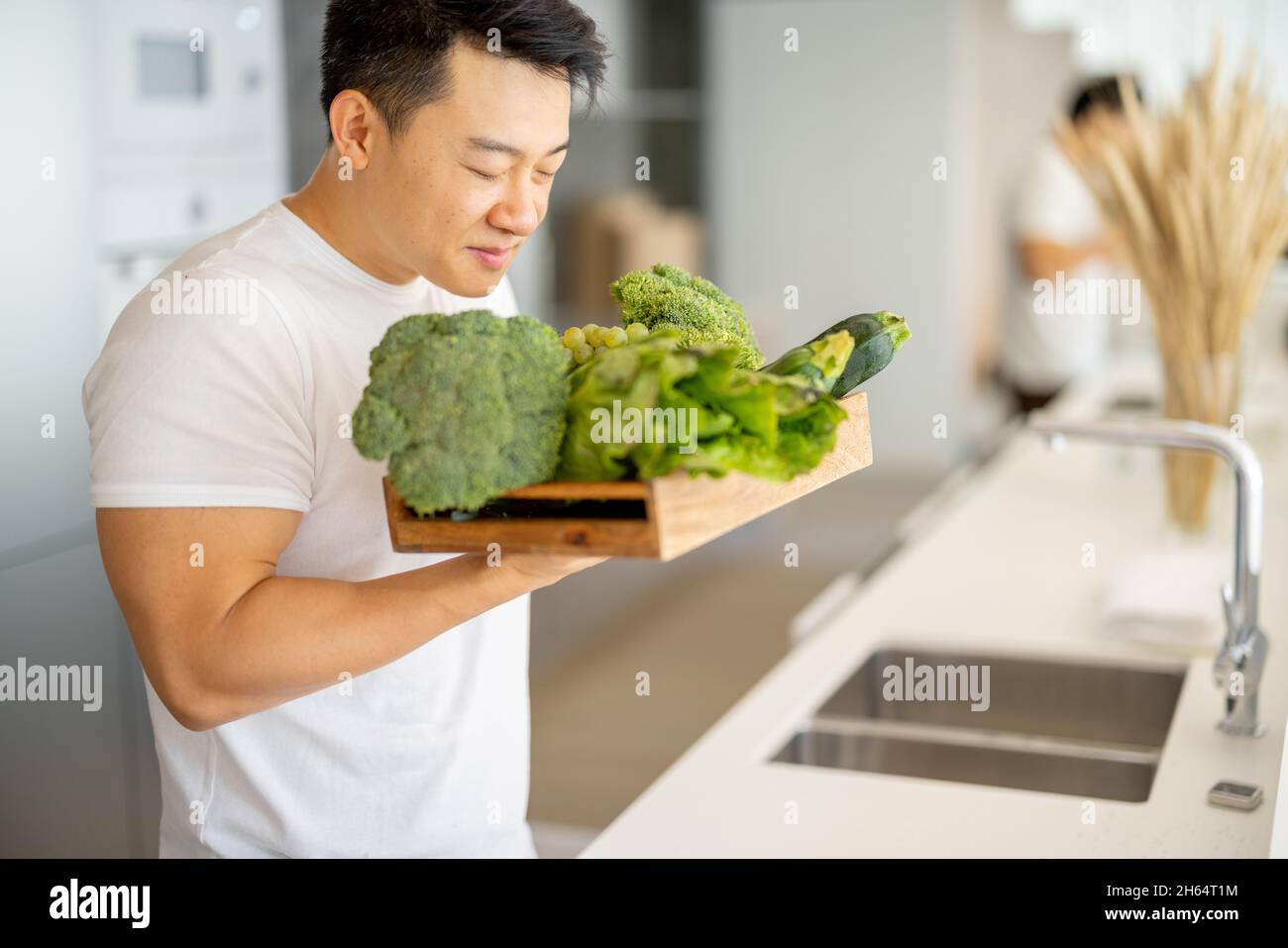 Mann schnüffeln frisches Bio-Gemüse in Holzkiste Stockfoto