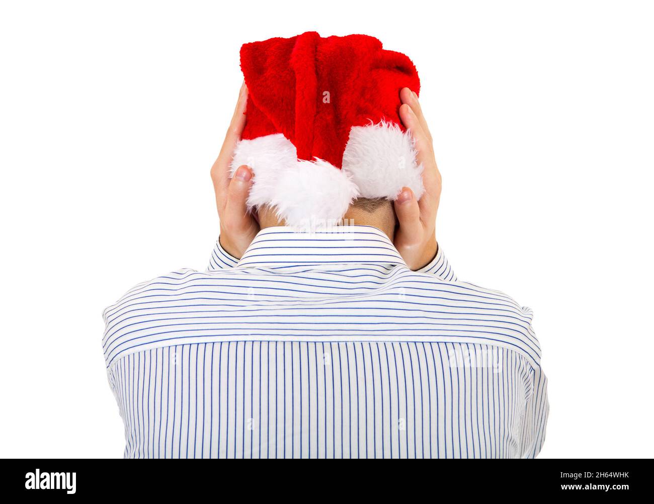 Rückansicht des Mannes in Santa hat, der seine Ohren auf dem weißen Hintergrund bedeckt Stockfoto