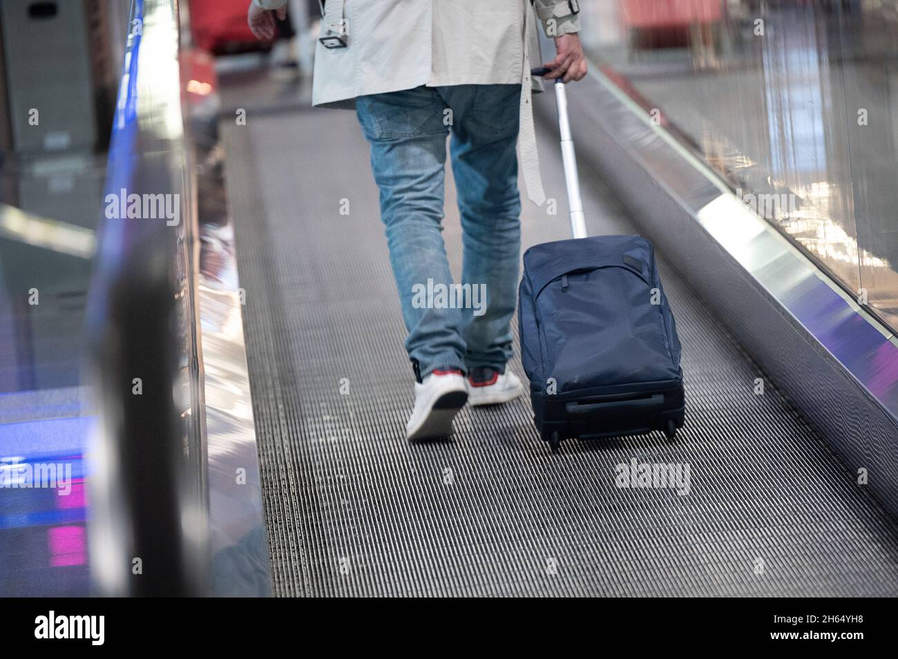 08. November 2021, Hessen, Frankfurt/Main: Ein Reisender trägt am Frankfurter Flughafen einen Koffer Foto: Sebastian Gollnow/dpa Stockfoto