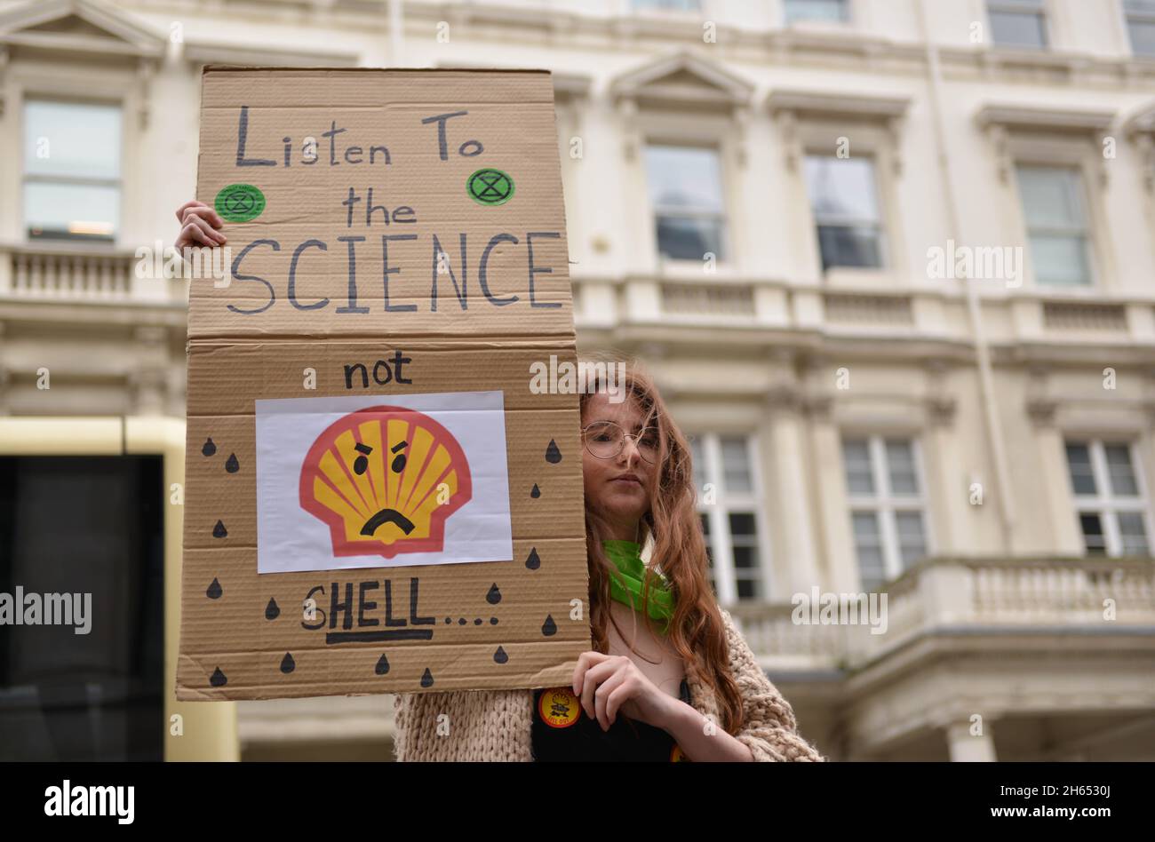 Ein Protestler hält während der Demonstration ein Plakat mit dem Titel „Höre der Wissenschaft zu, nicht der Muschel“. Extinction Rebellion-Aktivisten veranstalteten einen Protest gegenüber dem Science Museum in South Kensington gegen das Sponsoring des Museums durch die fossilen Energiekonzerne Shell und Adani. Stockfoto