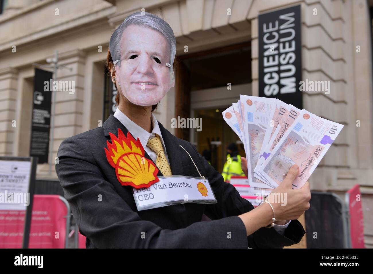 Ein Protestler, der als Shell-CEO Ben van Beurden gekleidet ist, posiert während der Demonstration mit gefälschtem Geld. Extinction Rebellion-Aktivisten veranstalteten einen Protest gegenüber dem Science Museum in South Kensington gegen das Sponsoring des Museums durch die fossilen Energiekonzerne Shell und Adani. Stockfoto