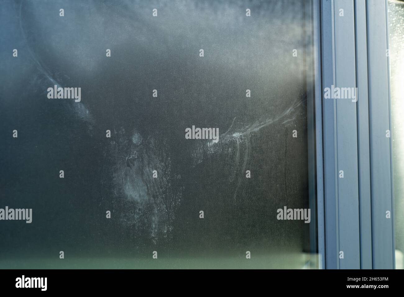 Ein Vogeldruck auf dem Glas eines Fensters. Die Markierung, die ein Vogel durch versehentliches Fliegen in ein Fenster gemacht hat. Flügel und Körperform deutlich sichtbar. Stockfoto