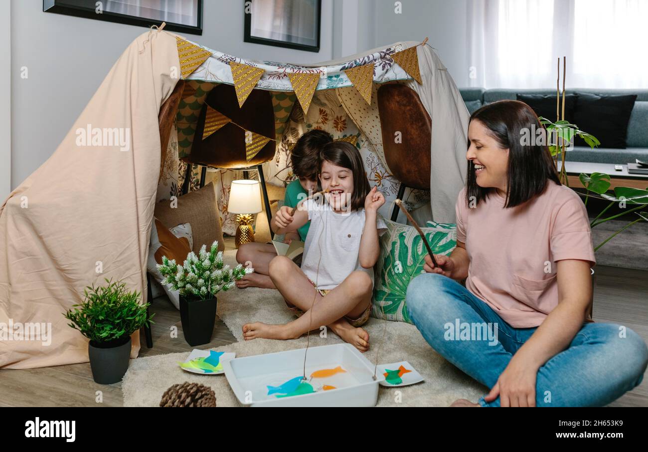 Glückliche Mutter und Tochter camping zu Hause spielen diy Angelspiel Stockfoto