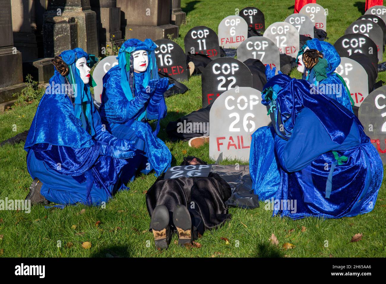 Die Rote Rebellenbrigade schließt sich der Blauen Rebellenbrigade auf dem Friedhof der Glasgow Necropolis zum Begräbnisfeier der COP26 an. Die weinenden Klimaaktivisten empfinden die COP26 als gescheitert und haben eine Scheinbegräbnis für den Gipfel abgehalten. Die COP26 wird zusammen mit allen vorherigen COP-Gipfeln in einem Grab ruhen. Stockfoto