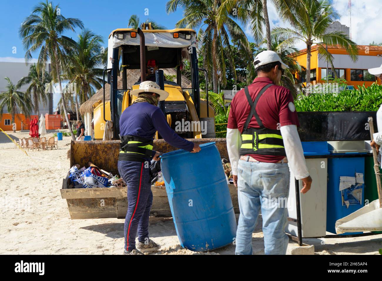 Der Müllwagenbetreiber Müllcontainer, um den Strand während der Sommerferiensaison in Playa del Carmen, Mexiko, sauber zu halten. Öko-Tourismus-Konzept Stockfoto
