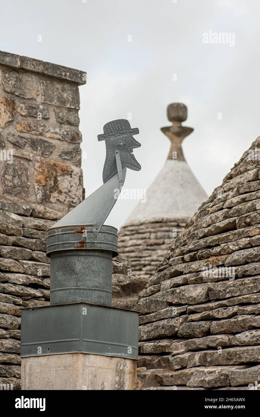 Altes Trullo-Dach mit typischen handgefertigten Windfahne auf dem Land, traditionelles altes Haus und alte Steinmauer in Apulien, Italien, Europa, vertikal Stockfoto