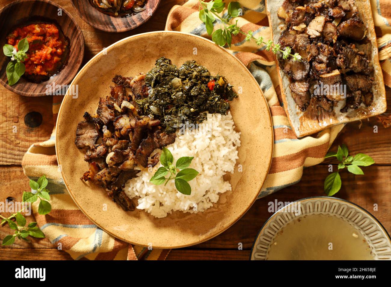 SE'i Sapi. Geräuchertes Rindergericht aus Nusa Tenggara Timur, serviert mit Reis und Cassava-Blättern Stockfoto