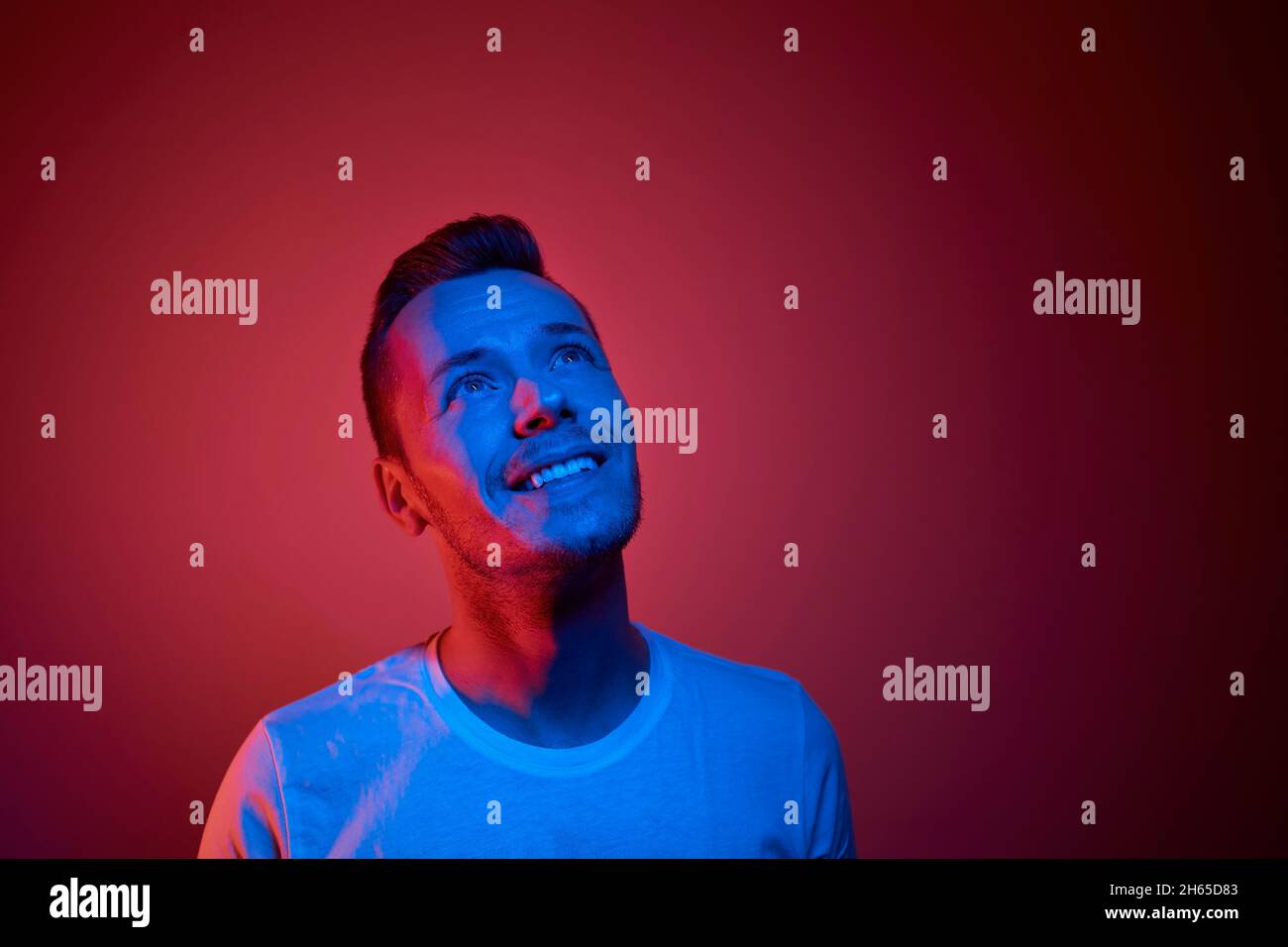 Porträt beleuchtet von Neonlicht. Erfolgreicher und entschlossener junger Mann. Stockfoto