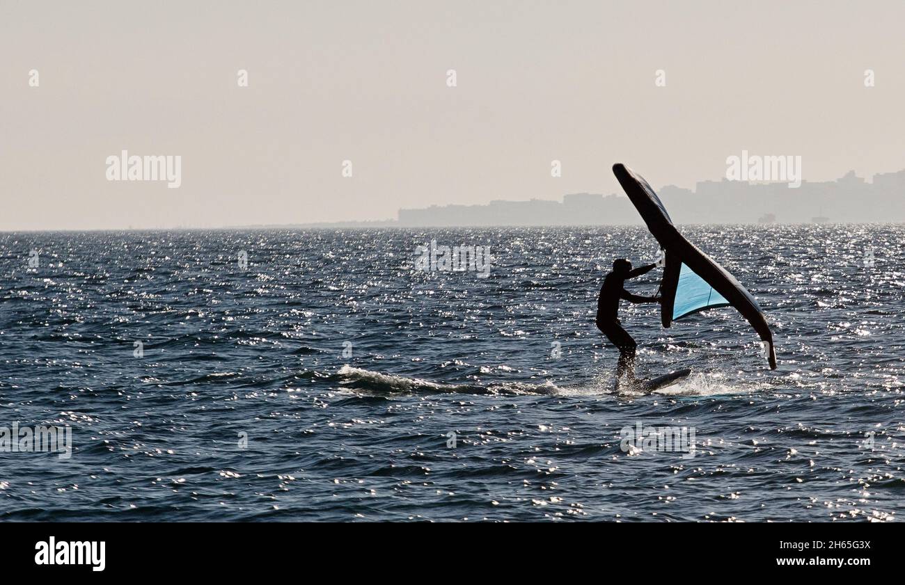 Junger Mann mit Wingfoil am Strand Stockfoto