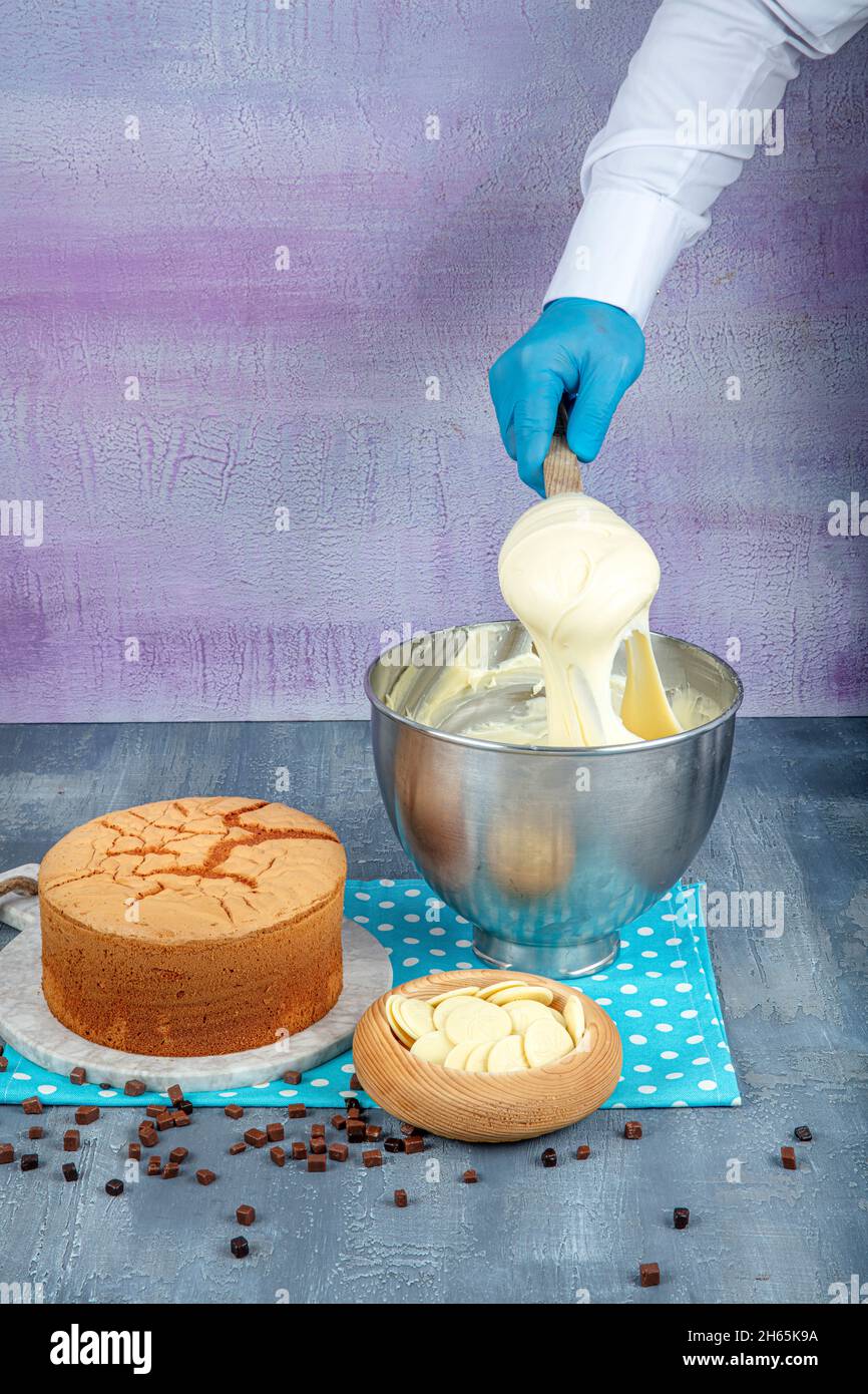 Kuchen Backen. Herstellung einer Creme für hausgemachte Kuchen auf einem Mixer. Herstellung von Kuchen Putting Creme mit Spatel.hausgemachte Bäckerei Kochen Konzept. Stockfoto