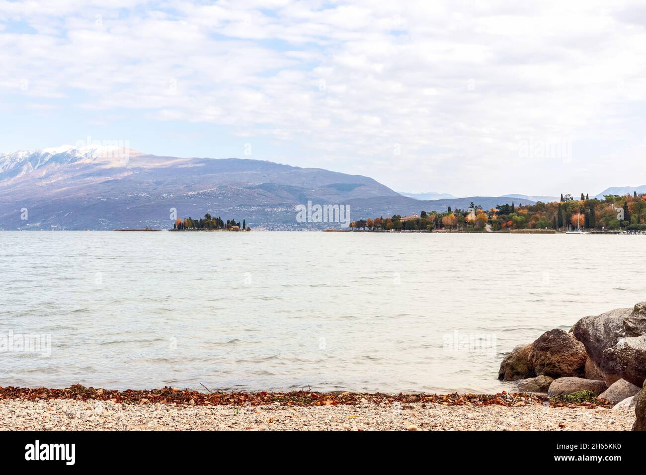 Kiesstrand am Gardasee mit Blick auf die kleine Insel Rabit (Herbstzeit) Stockfoto