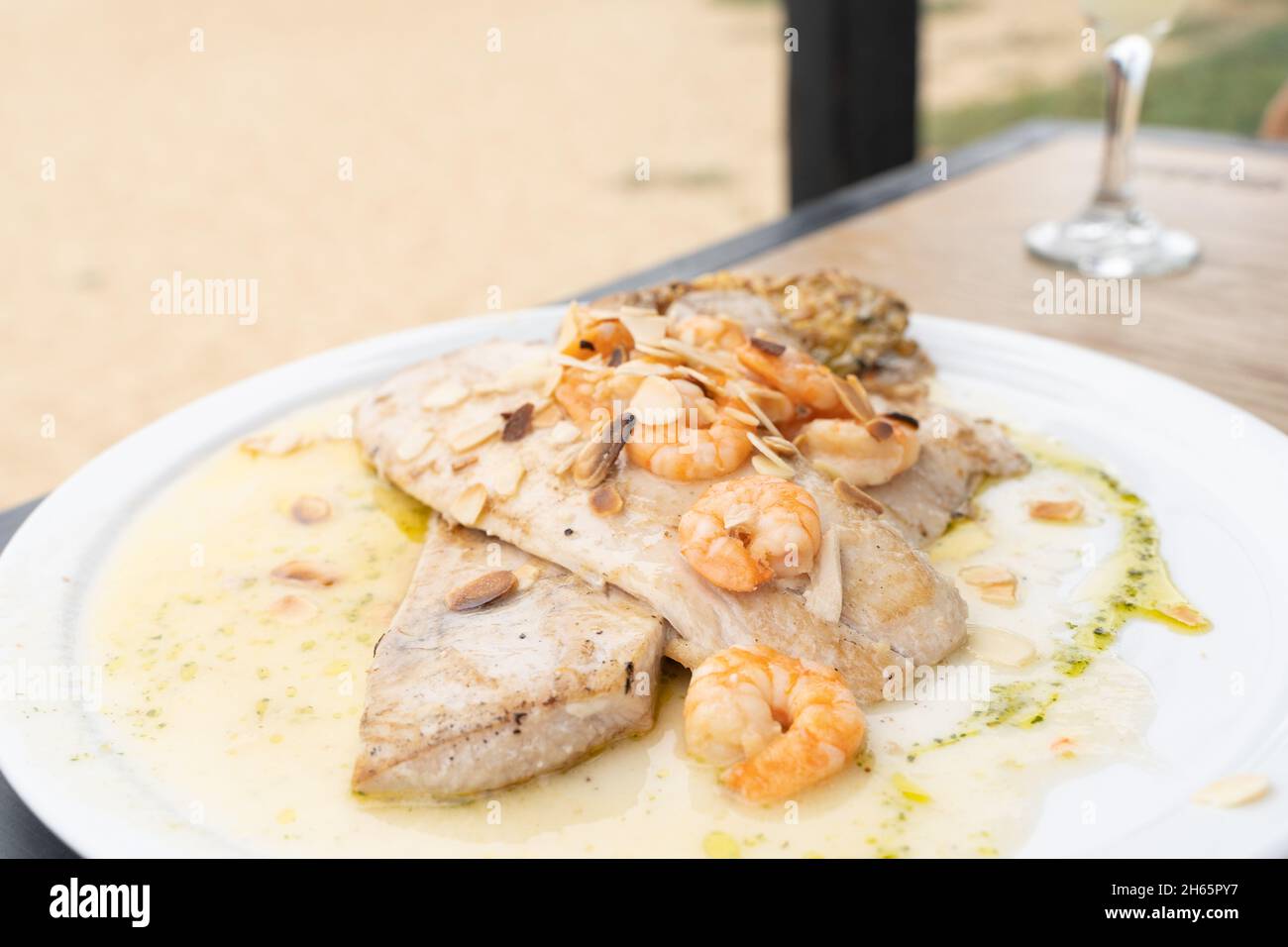 Gegrilltes Fischsteak mit Garnelen und Mandeln auf Öl. Restaurant Essen Menüteller, Hauptgericht Konzepte Stockfoto