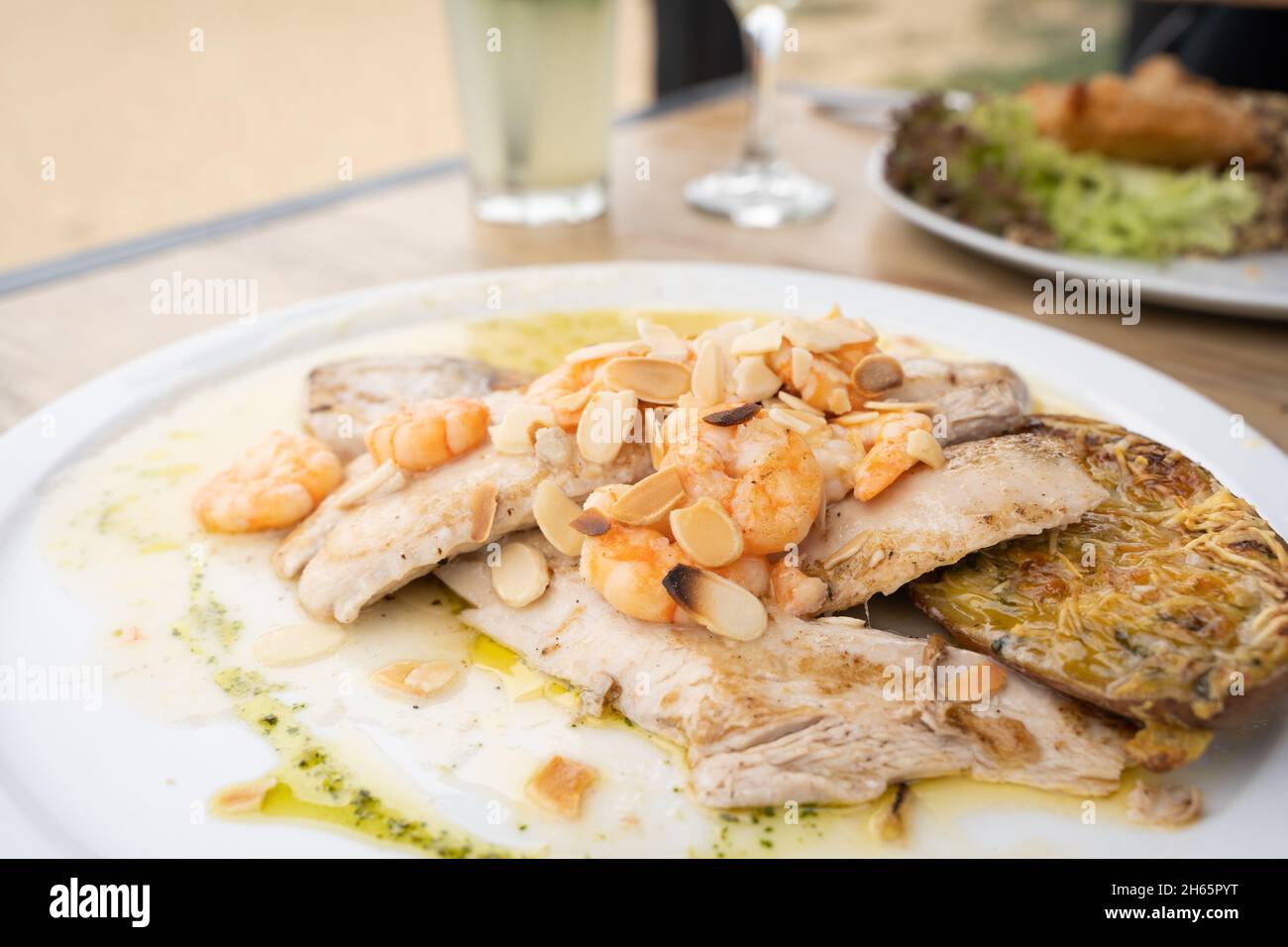 Gegrillter Fischteller mit Garnelen und Mandeln auf Öl. Konzept der Speisekarte im Restaurant Stockfoto