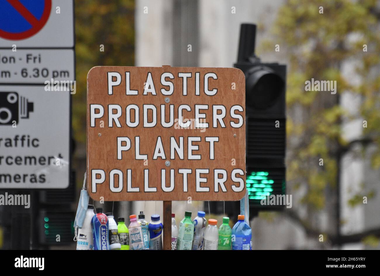 Ein Protestschild lautet „Plastic Producers Planet Polluters“, das von einem Protestierenden gegen Einweg-Plastik und seine Umweltauswirkungen festgehalten wird Stockfoto
