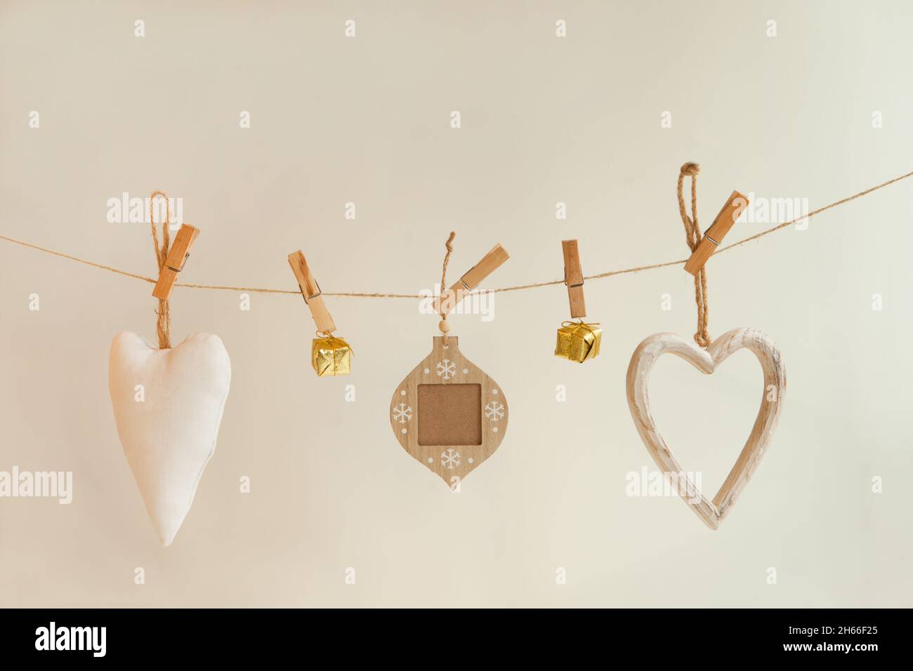 Weiße und goldene weihnachtsdekorationen am Seil befestigt. Stoff- und Textilschmuck hängen auf Weiß Stockfoto