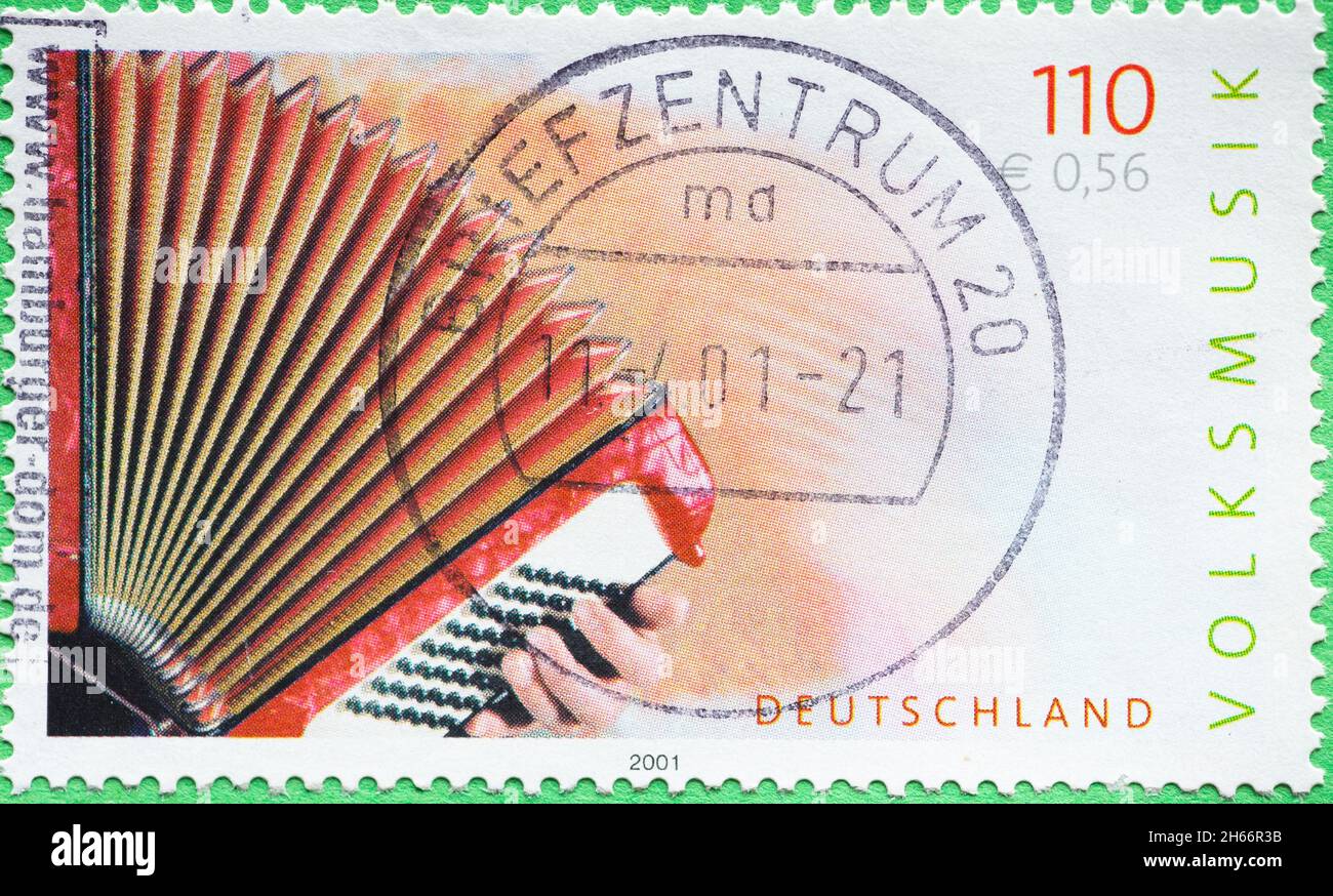 DEUTSCHLAND - UM 2001 : eine Briefmarke aus Deutschland, die ein Bild einer roten Ziehharmonika zeigt. Text: Volksmusik Stockfoto