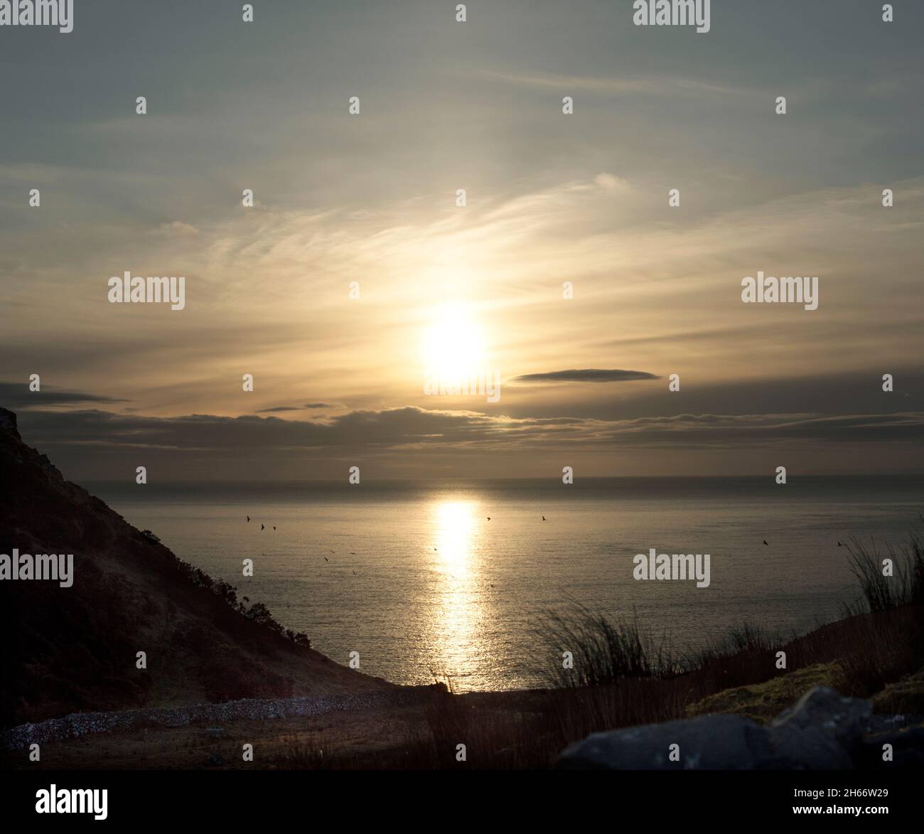 Ein Blick auf den Nordatlantik schoss, als die Wintersonne über der irischen Küste aufgeht. Stockfoto