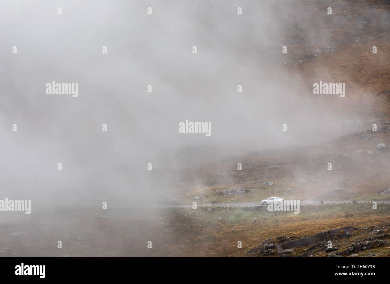 Healy Pass, Cork, Irland. November 2021. Ein Auto fährt langsam die schmale Bergstraße entlang, während Nebel und Nebel auf dem Healy Pass, Co. Cork, Irland, herabsteigen. - Bild; David Creedon / Alamy Live News Stockfoto