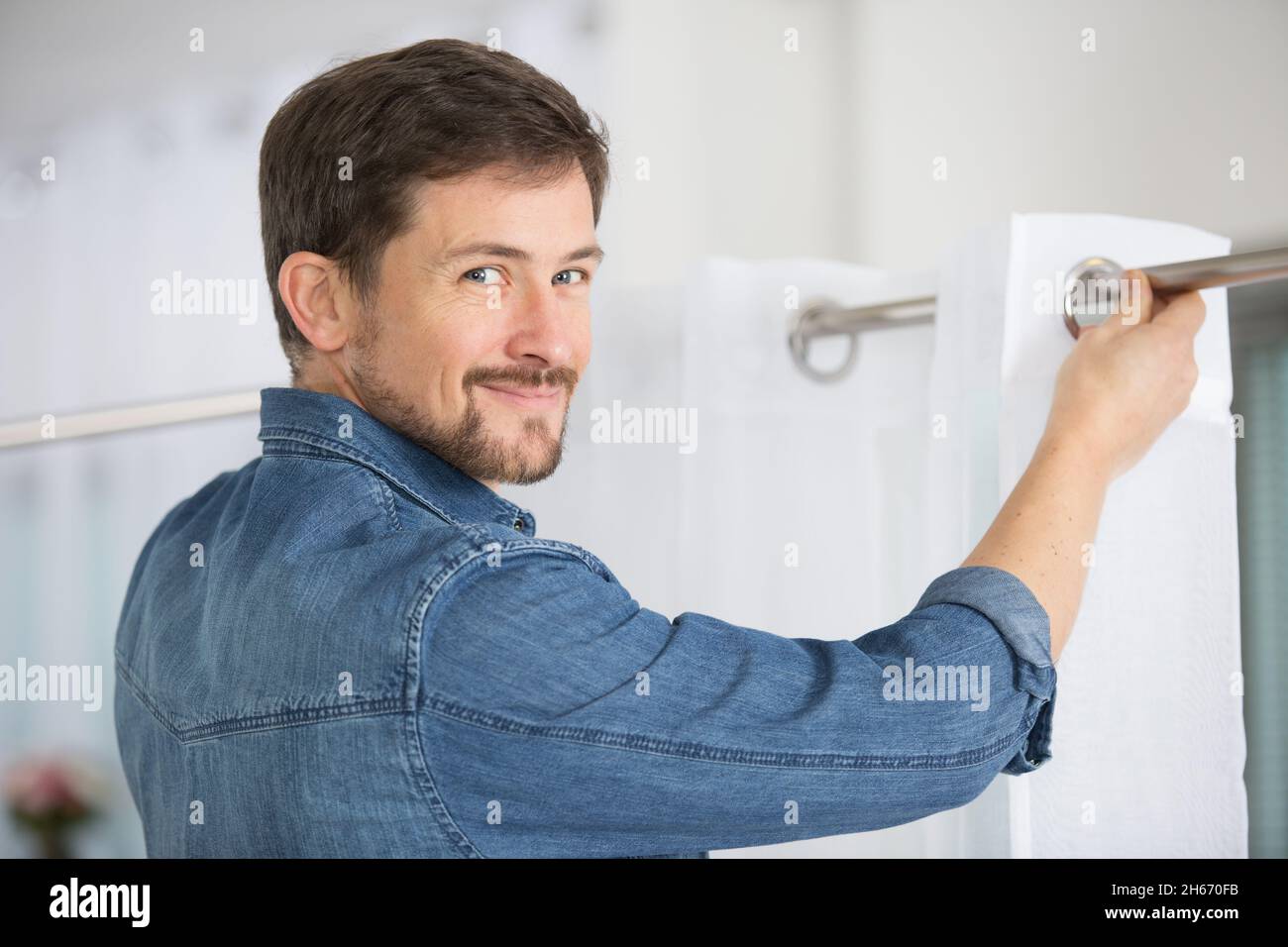 Stecker, der einen Vorhang installiert Stockfoto